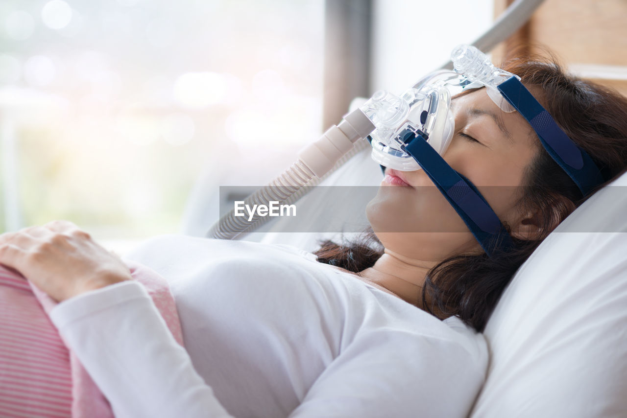 Close-up of woman on bed in hospital