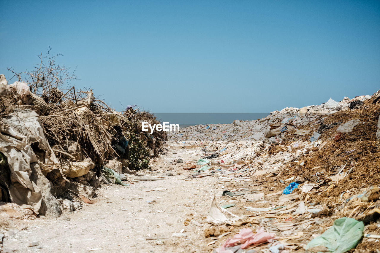 Garbage at beach against clear blue sky