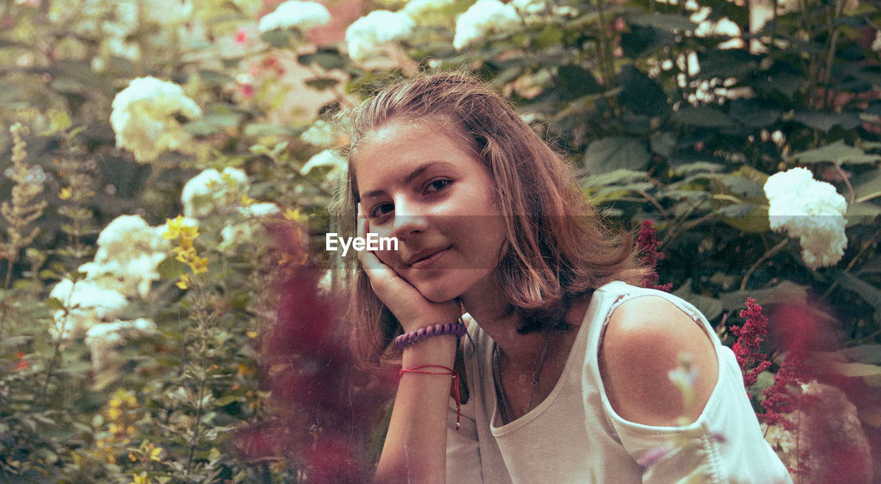 Portrait of smiling teenage girl against plants