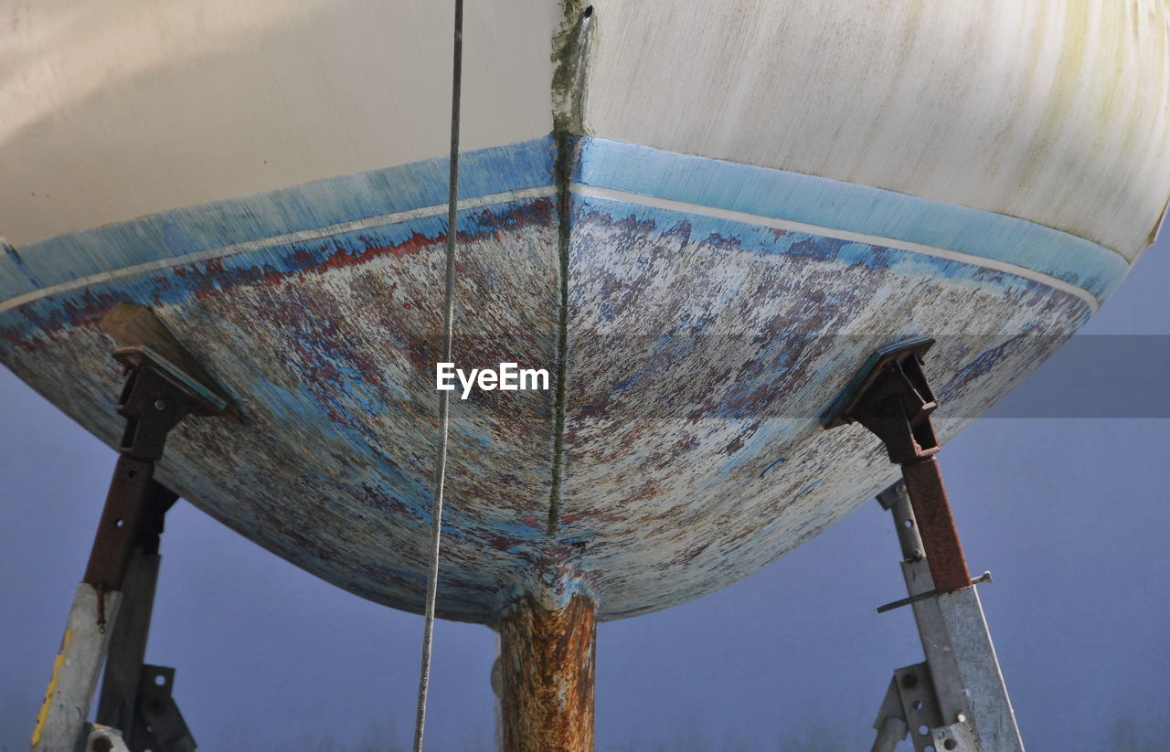 LOW ANGLE VIEW OF RUSTY METALLIC STRUCTURE AGAINST SKY