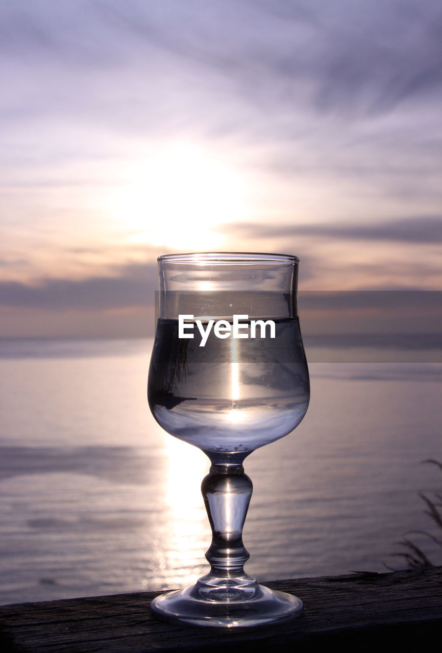 Reflection of sunset on water in drinking glasses