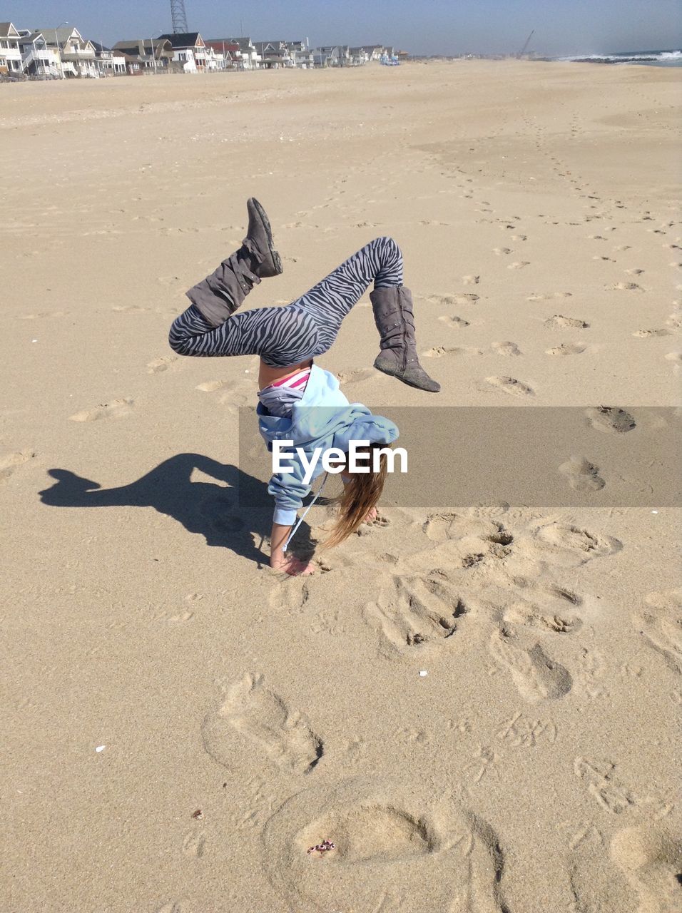 High angle view of woman doing handstand on sand at beach