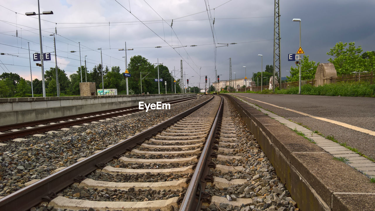 Railroad tracks by platform against sky