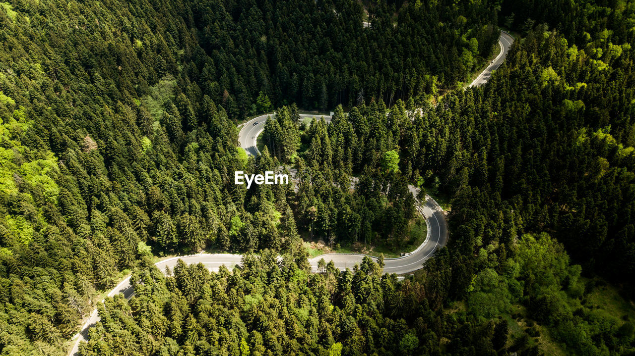 Winding road from high mountain pass, in summer time. aerial view by drone . romania