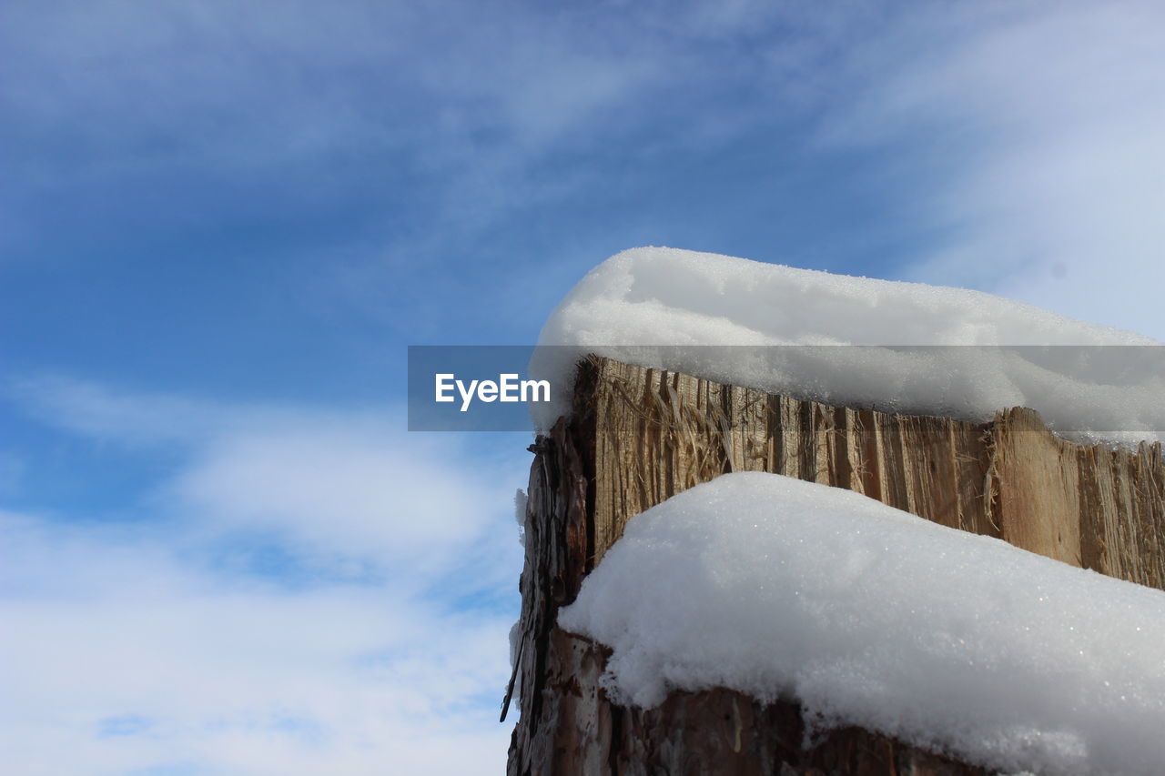 Low angle view of snow covered mountain against sky