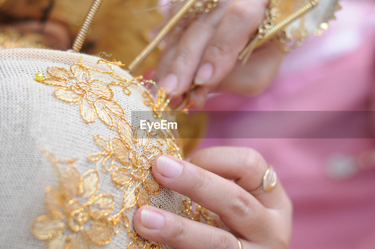 Cropped image of woman making floral pattern on fabric