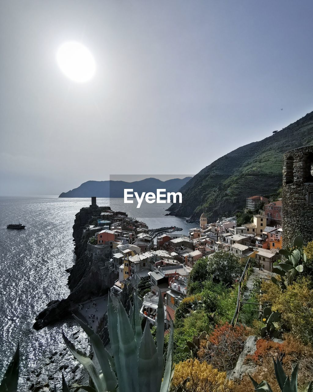 SCENIC VIEW OF SEA AGAINST BUILDINGS AND MOUNTAINS