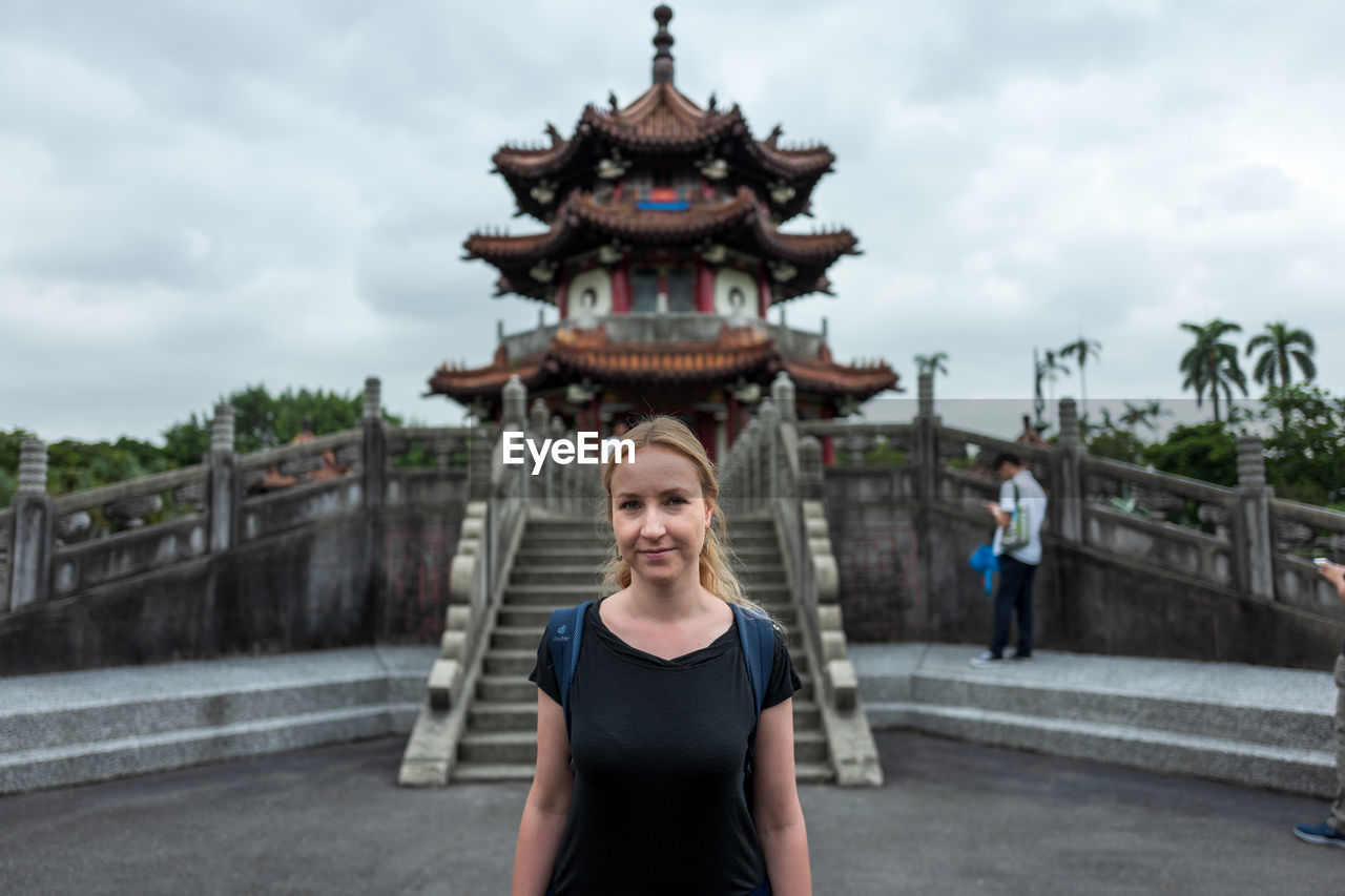 PORTRAIT OF WOMAN STANDING AGAINST SKY