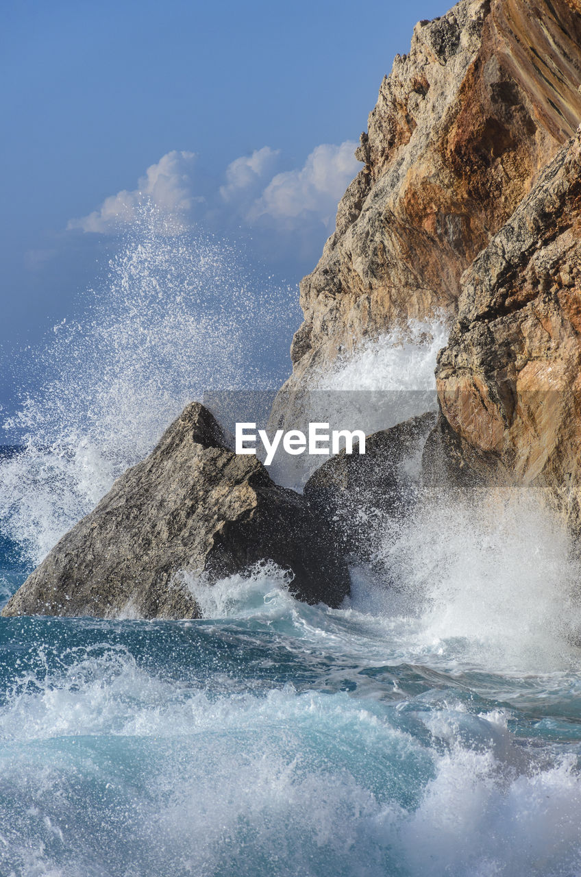 SCENIC VIEW OF SEA WAVES SPLASHING ON ROCKS