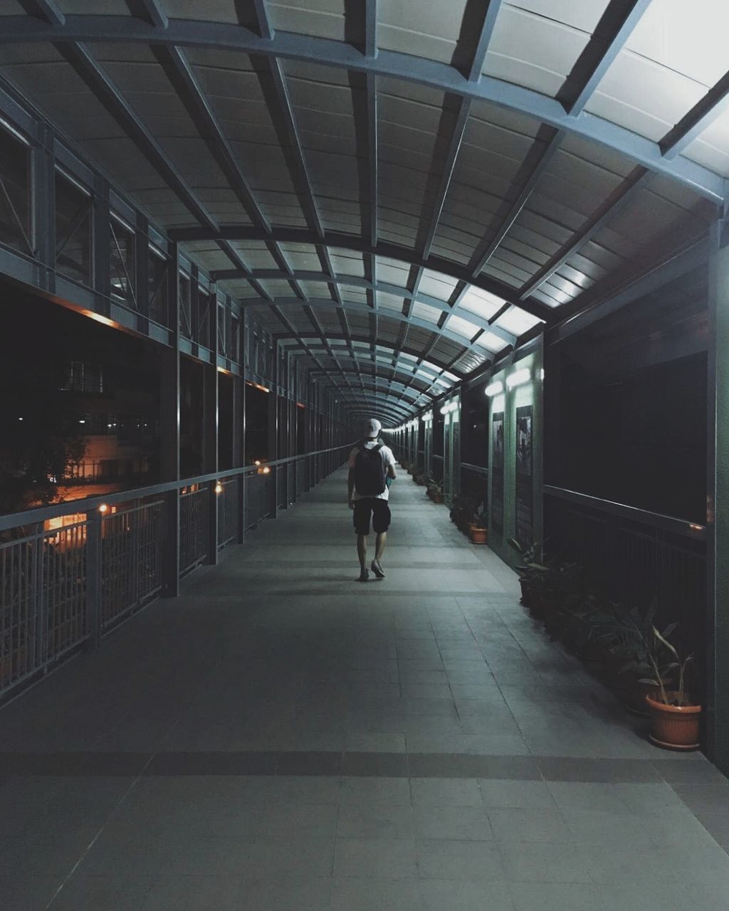 Full length of man walking on elevated walkway at night