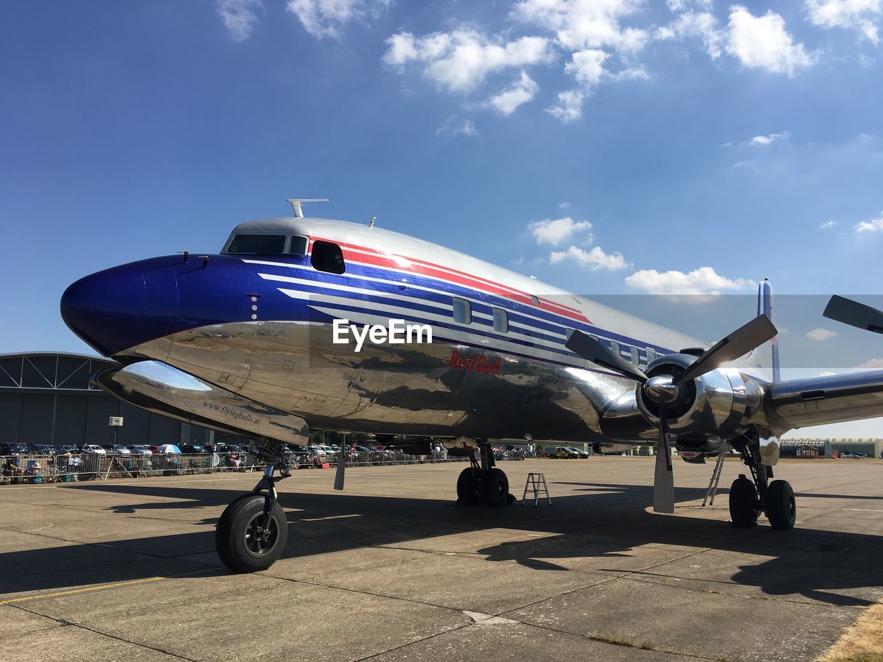 AIRPLANE ON AIRPORT RUNWAY AGAINST BLUE SKY