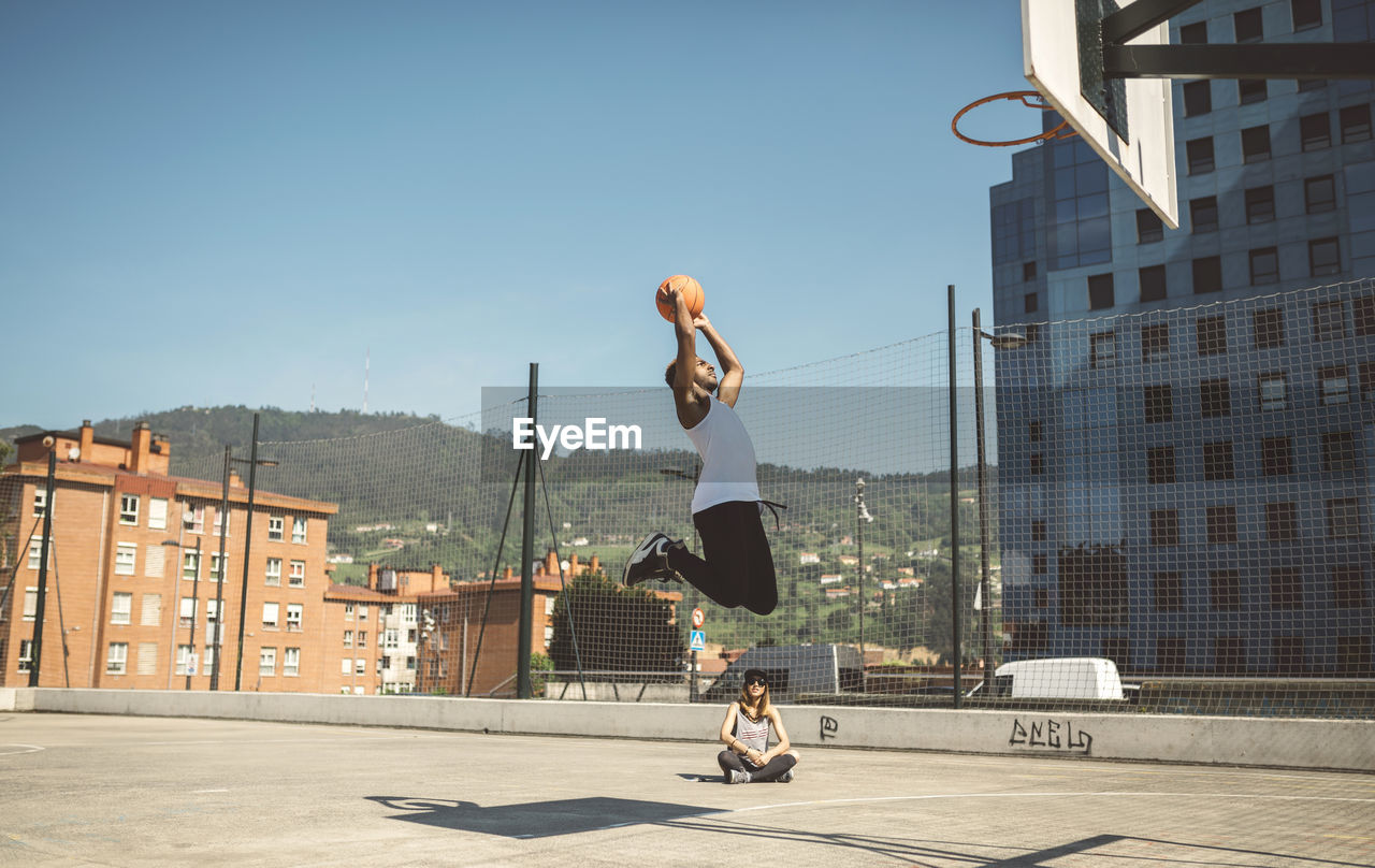 Young man aiming at basketball hoop