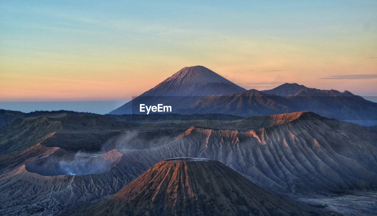 Scenic view of volcanic landscape against sky during sunset