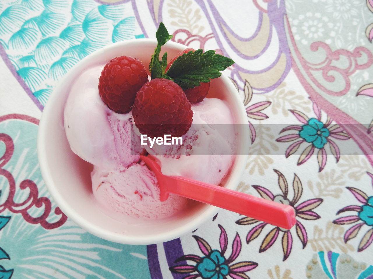 Close-up of ice cream and raspberries in bowl on table