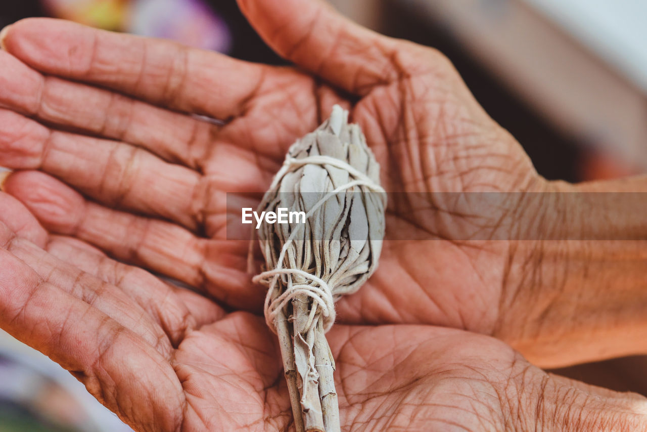CLOSE-UP OF HUMAN HAND HOLDING RING