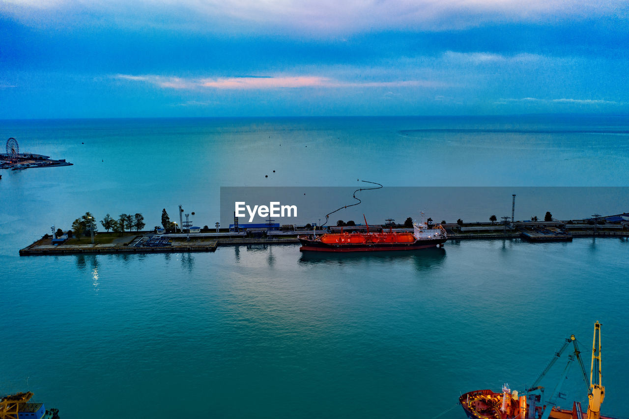 FISHING BOATS ON HARBOR AGAINST SKY