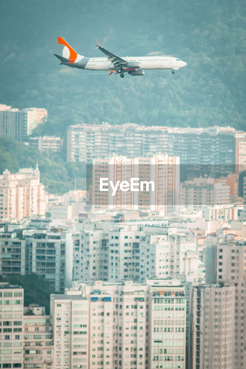 Airplane flying over the city and preparing for landing