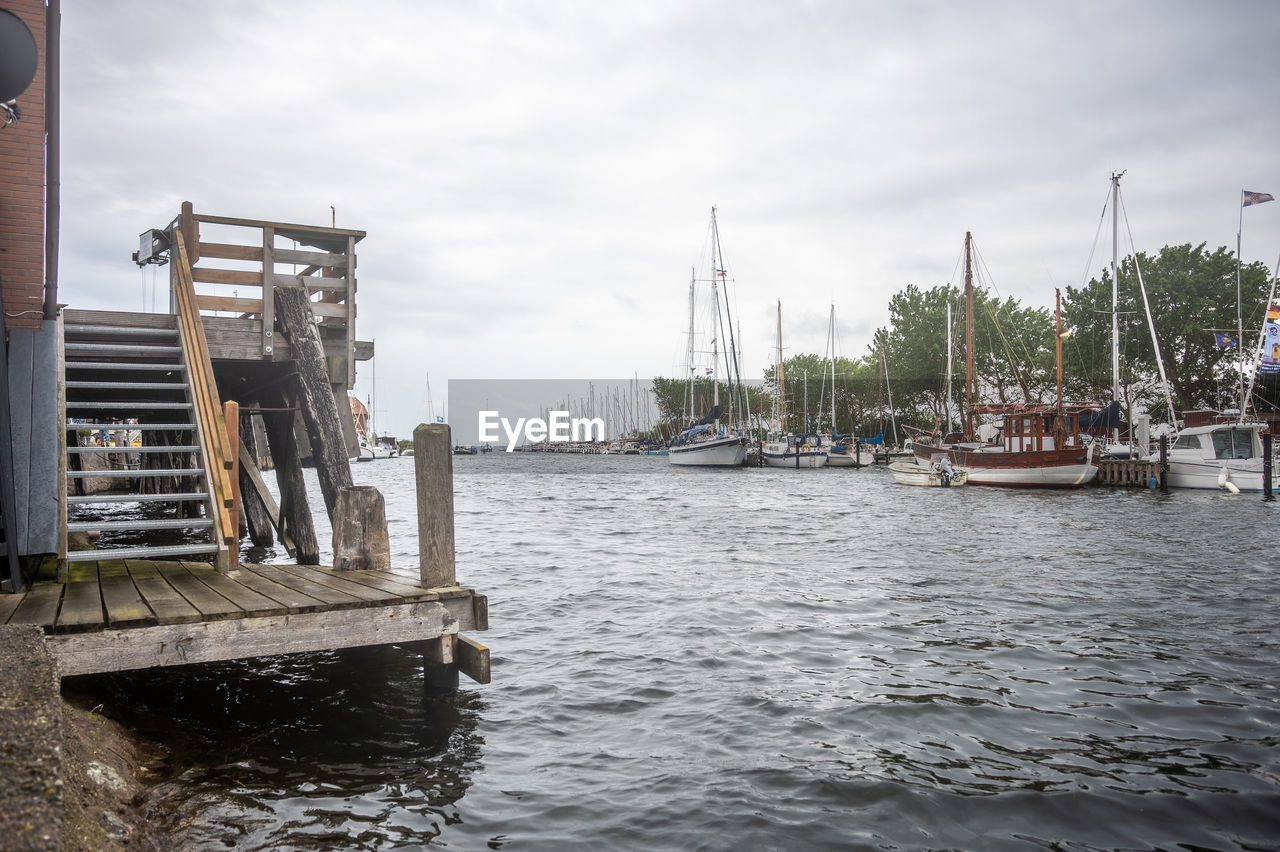 water, nautical vessel, transportation, sky, architecture, boat, mode of transportation, dock, sea, nature, cloud, waterway, harbor, ship, vehicle, sailboat, pier, built structure, day, city, travel, watercraft, travel destinations, no people, outdoors, marina, building exterior, channel, environment, waterfront, boating, vacation, holiday, trip, pole, tourism, mast, moored, wood