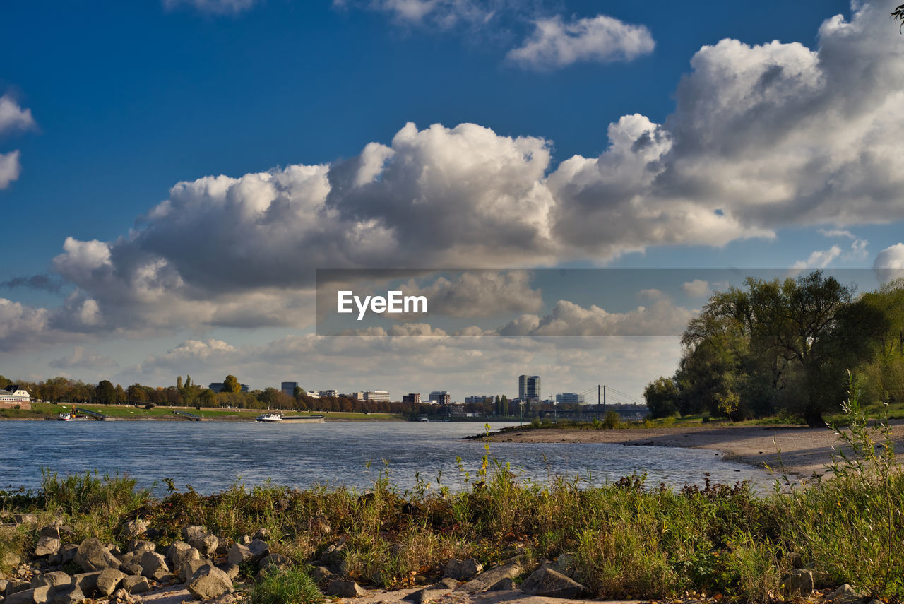 SCENIC VIEW OF RIVER AND CITY AGAINST SKY