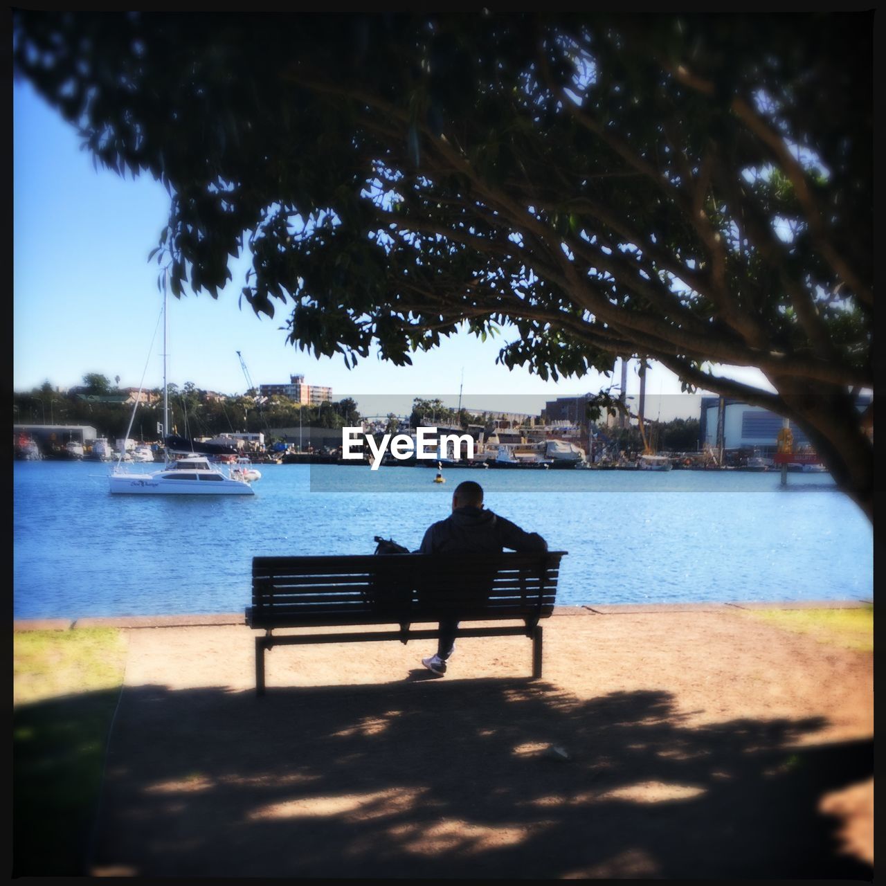 REAR VIEW OF WOMAN SITTING IN WATER