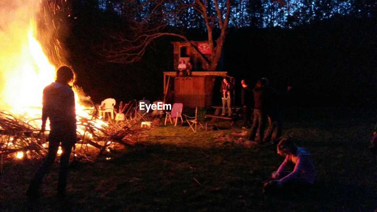 View of people near open fire in forest