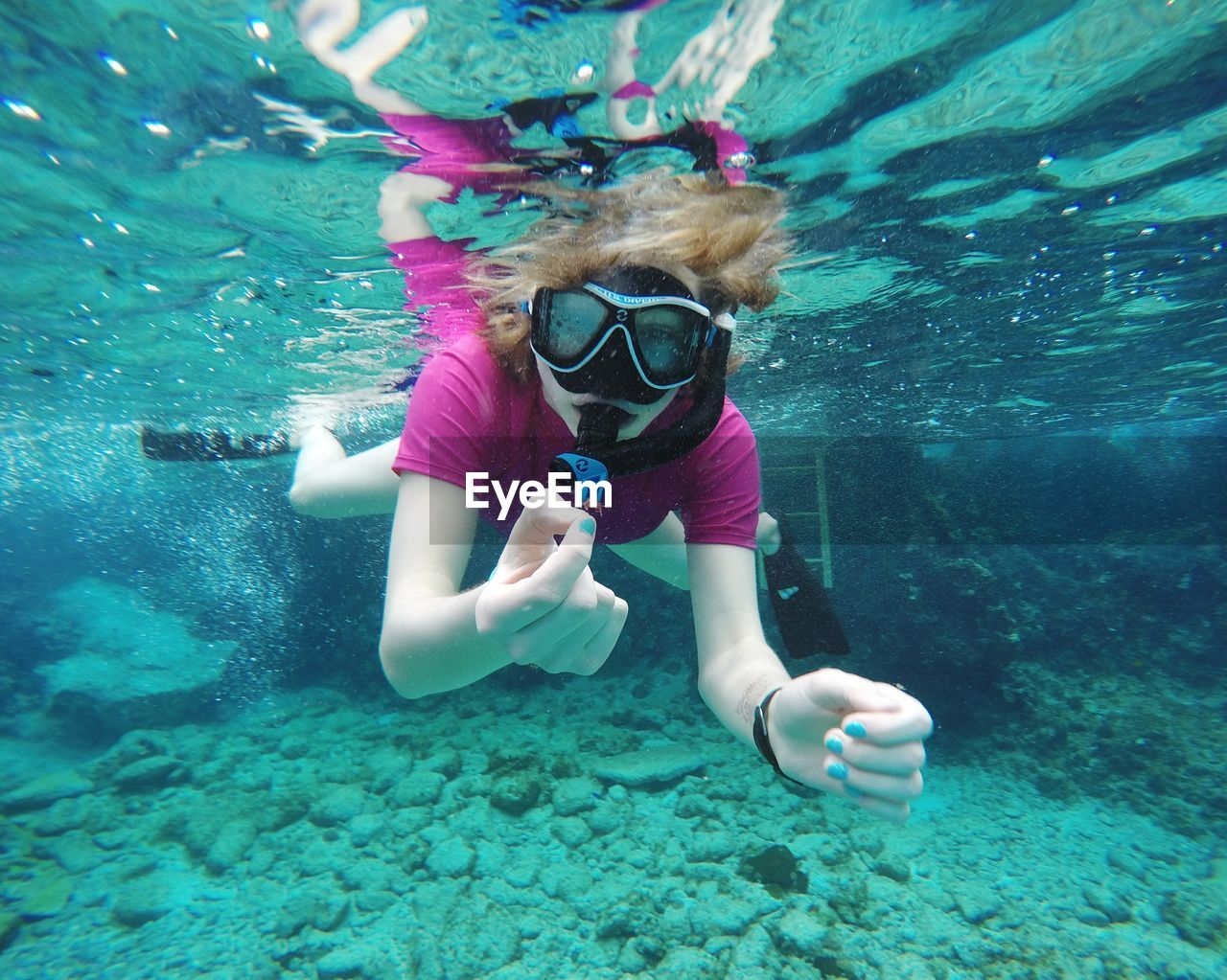 FULL LENGTH OF SMILING GIRL SWIMMING IN SEA