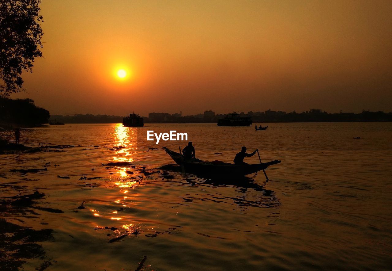 Silhouette boat in sea against sky during sunset
