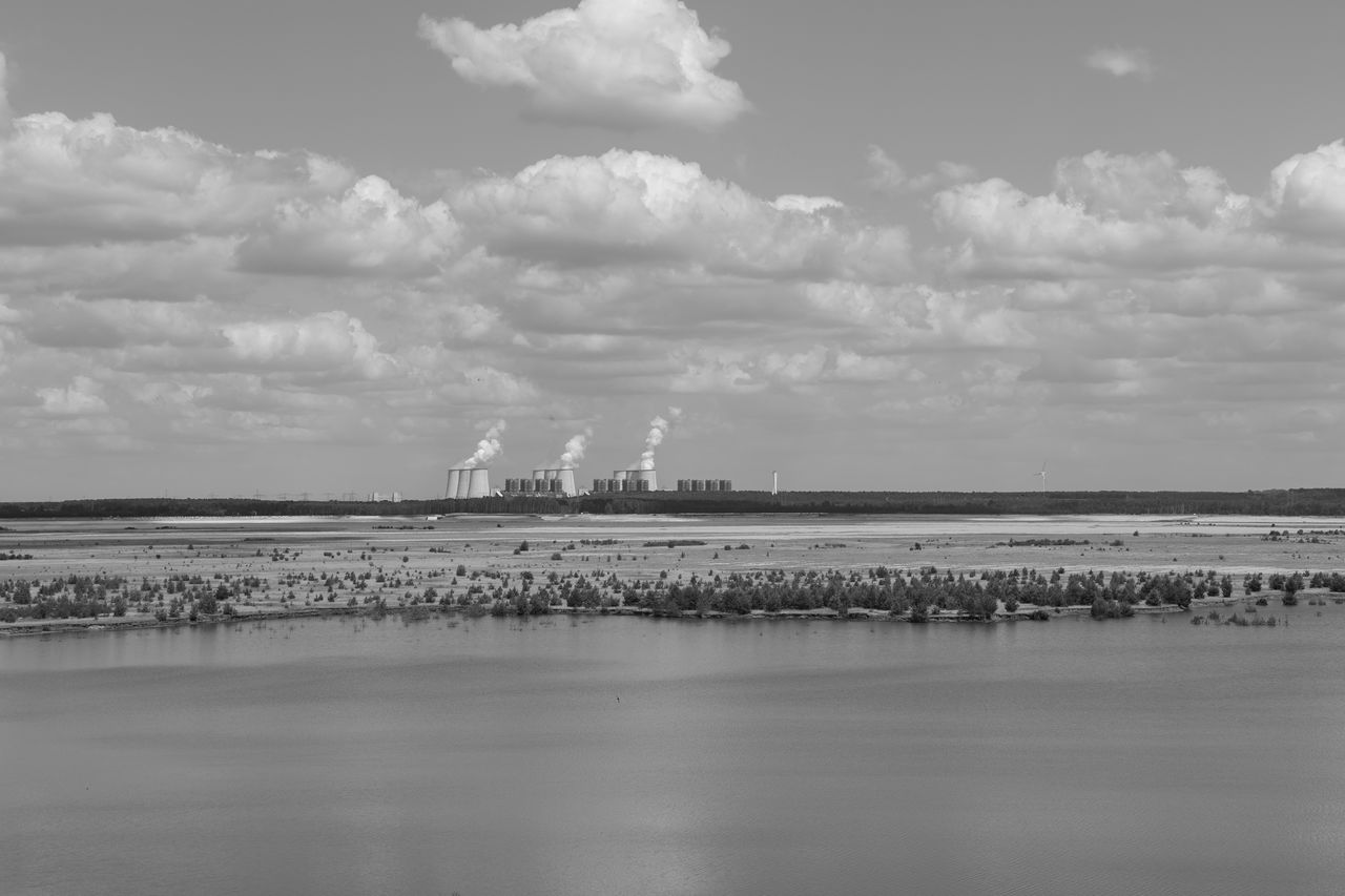 horizon, black and white, sky, water, cloud, monochrome photography, environment, industry, monochrome, nature, factory, sea, power generation, no people, day, landscape, reflection, outdoors, beauty in nature, wave, built structure, architecture, scenics - nature, shore, coast, business finance and industry, tower, land, white, tranquility, pollution, building exterior