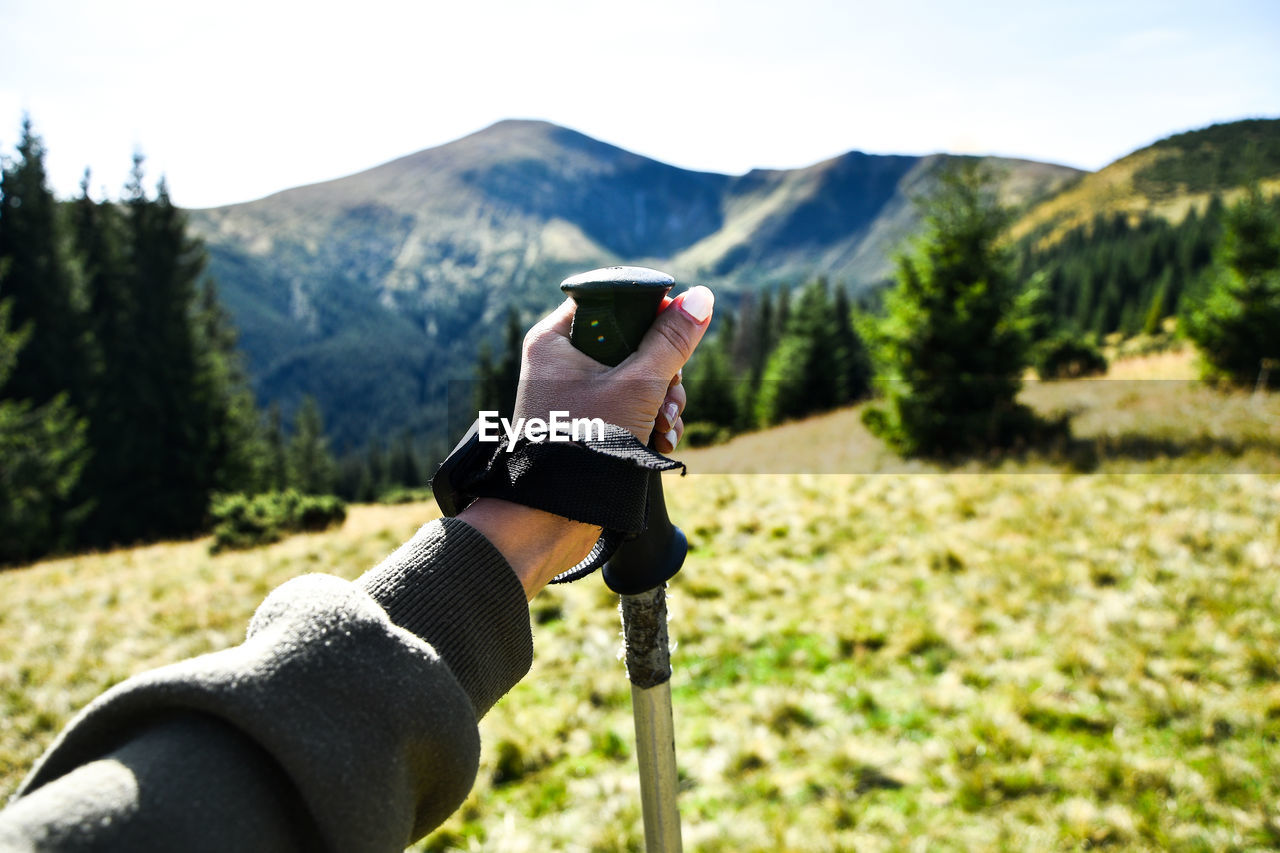 Trekking poles at top of mountain with beautiful view of autumn mountains. natural background. hand 