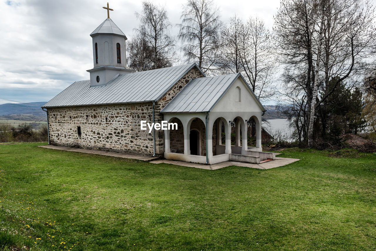 CHURCH ON FIELD AGAINST SKY