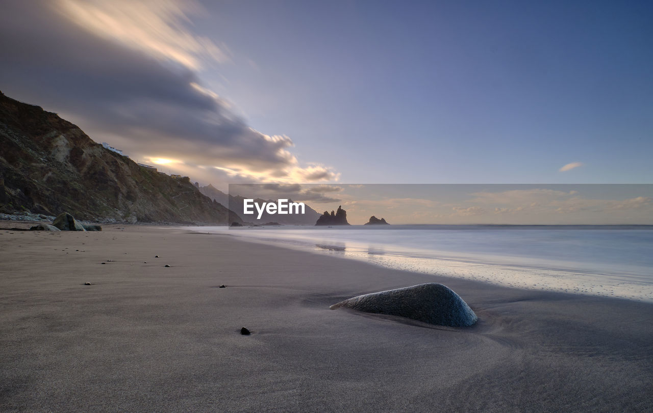 Scenic view of beach against sky during sunset