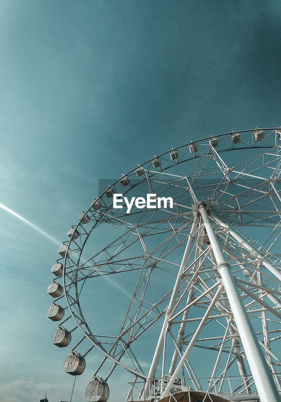 Low angle view of ferris wheel against blue sky