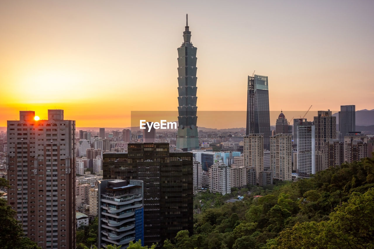 MODERN BUILDINGS IN CITY AT SUNSET