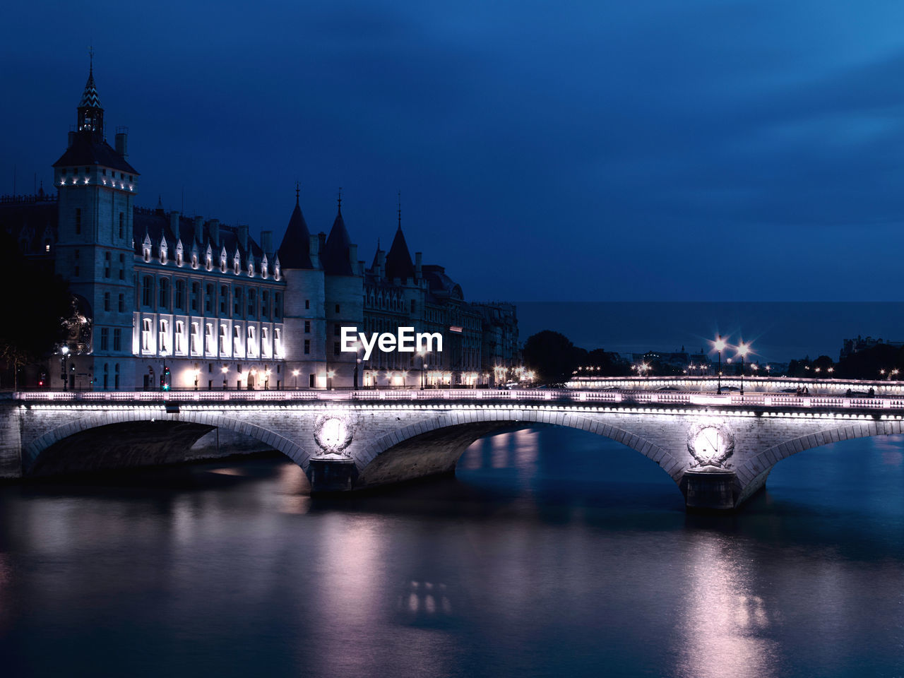 Bridge over river in city at night