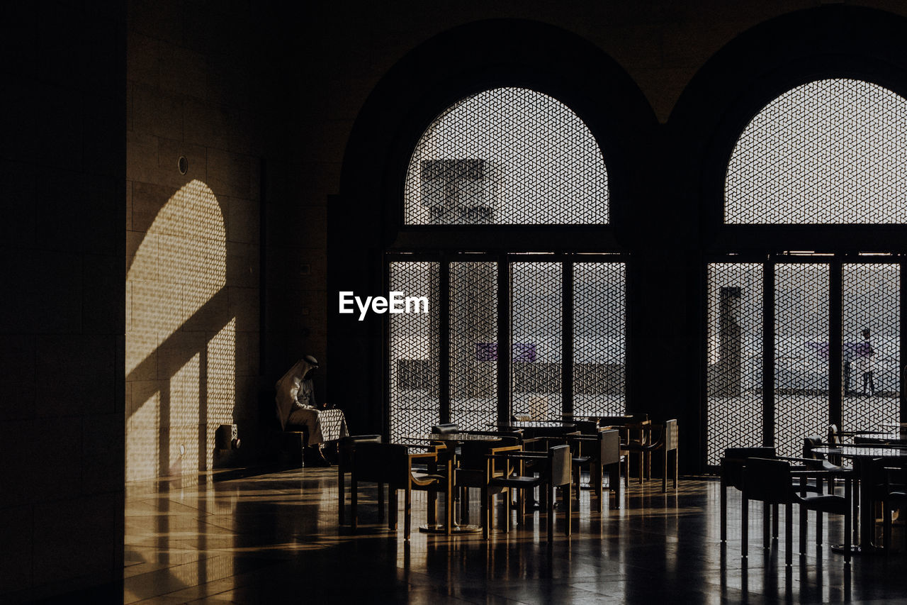 SILHOUETTE PEOPLE SITTING BY WINDOW ON BUILDING