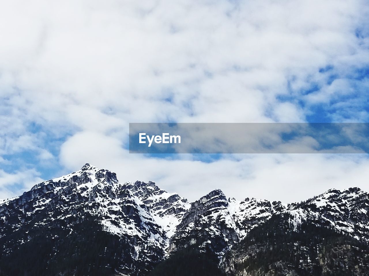 Low angle view of snowcapped mountains against sky