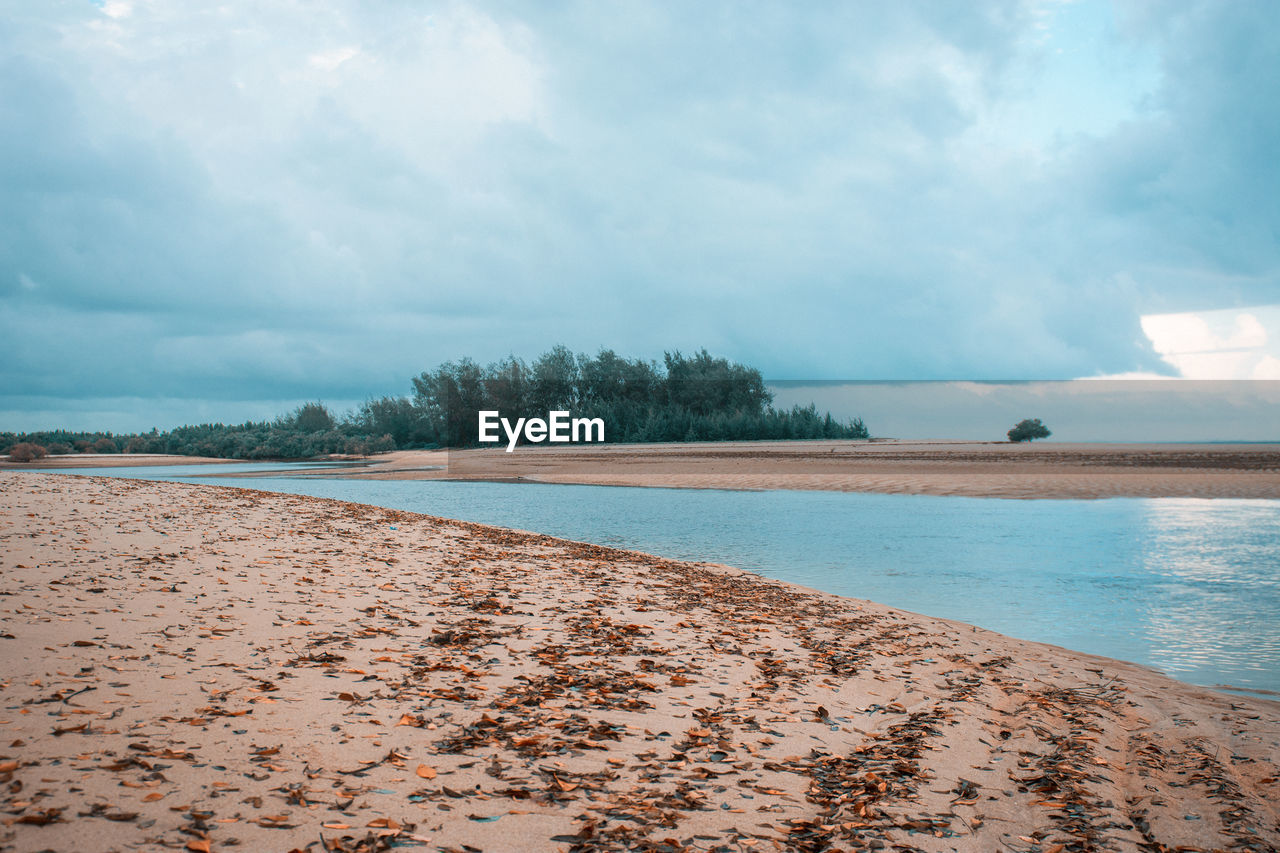 sky, water, cloud, shore, sea, land, body of water, horizon, ocean, beach, coast, scenics - nature, nature, beauty in nature, sand, environment, wave, tranquility, landscape, travel destinations, tranquil scene, bay, morning, travel, tree, no people, sunlight, outdoors, holiday, tourism, day, vacation, trip, coastline, cloudscape, blue, reflection, plant, lagoon, island, water's edge, non-urban scene, wind wave, idyllic, dramatic sky, seascape, overcast