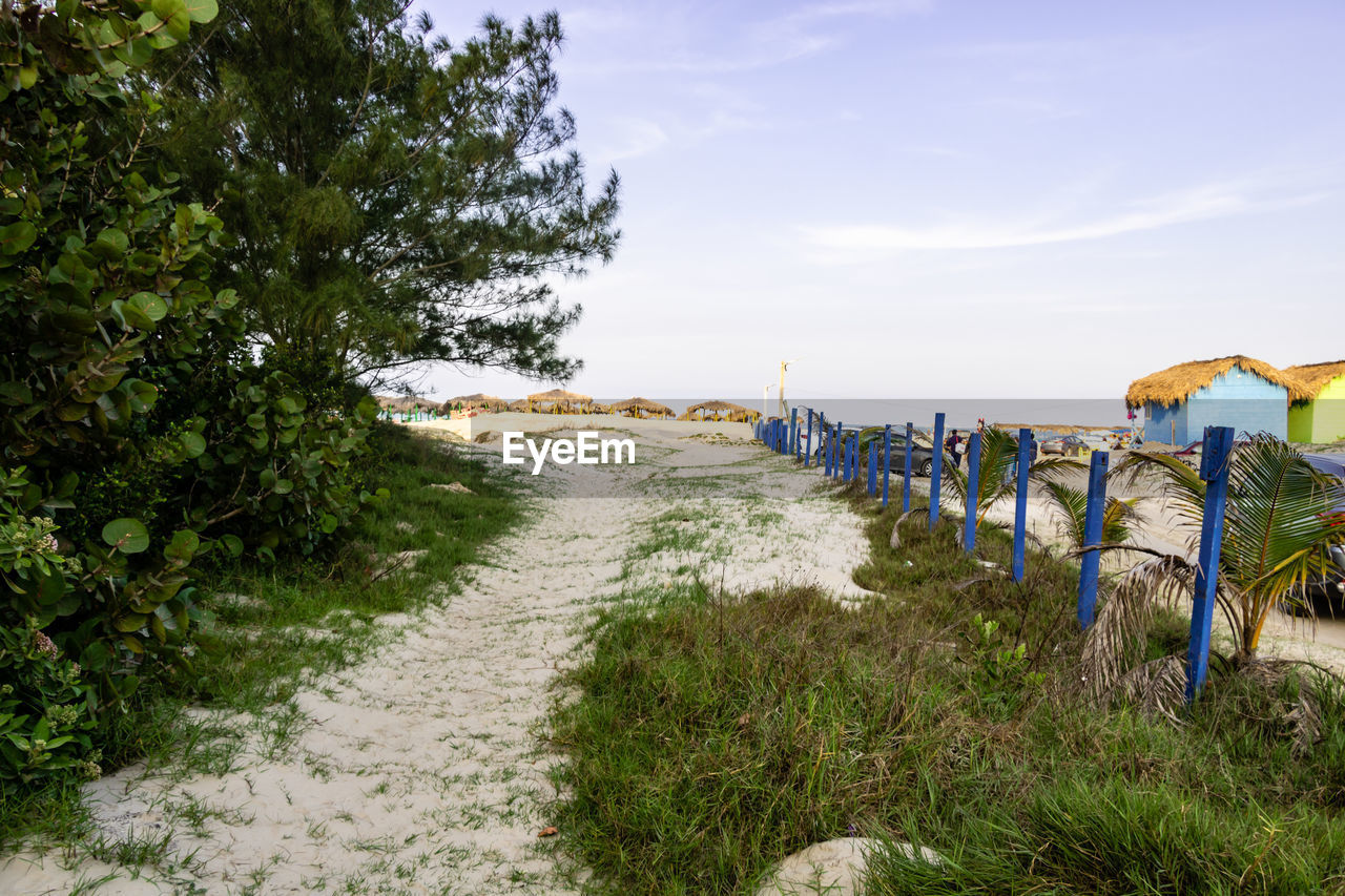 Footpath leading towards beach against sky