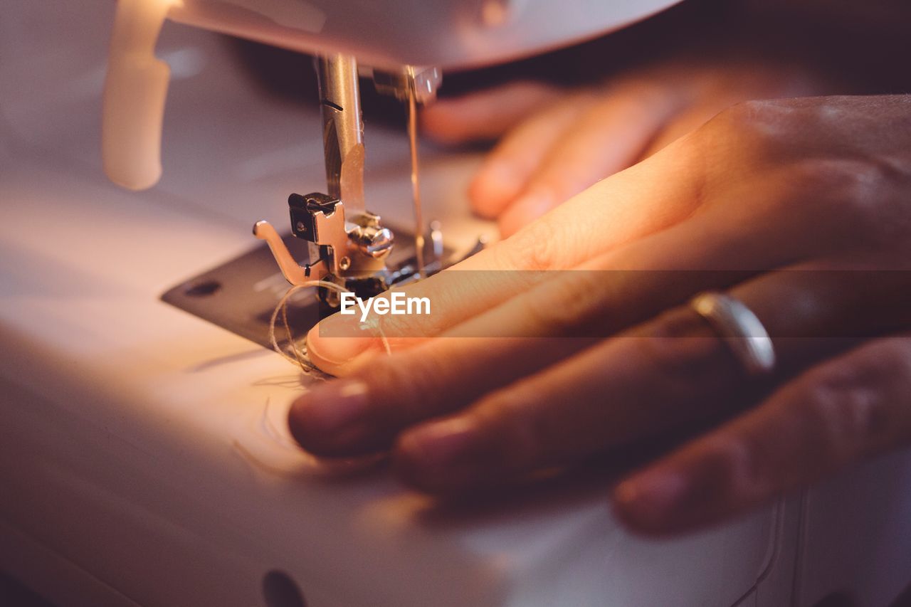 Cropped image of woman using sewing machine