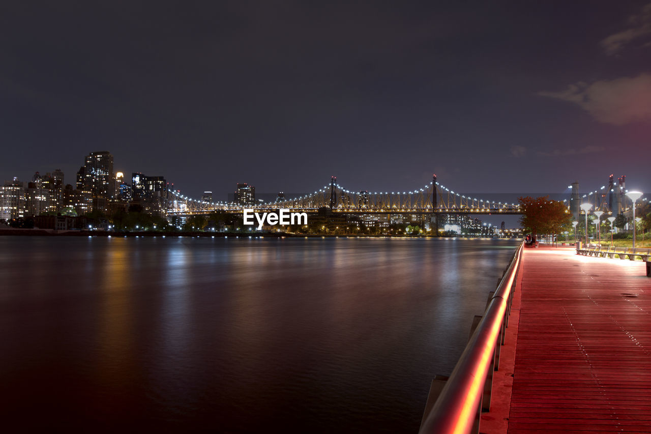 Illuminated queensboro bridge over river at night