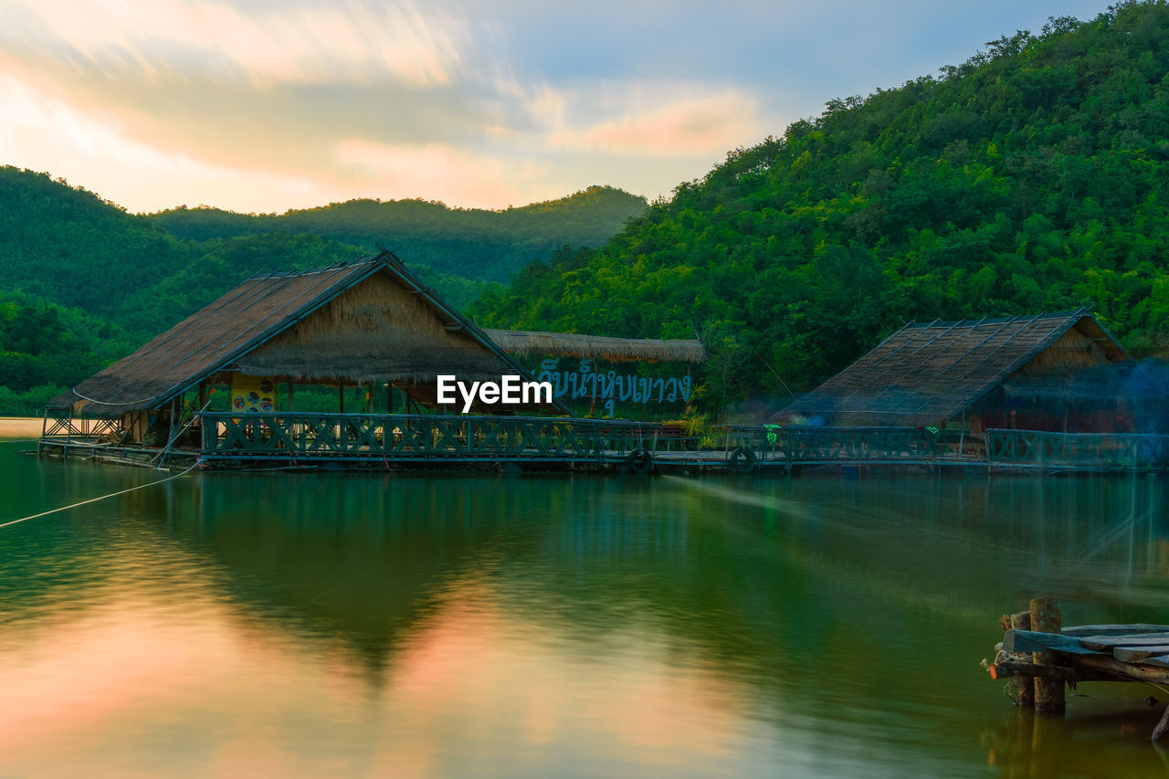 SCENIC VIEW OF LAKE AND HOUSES AGAINST SKY