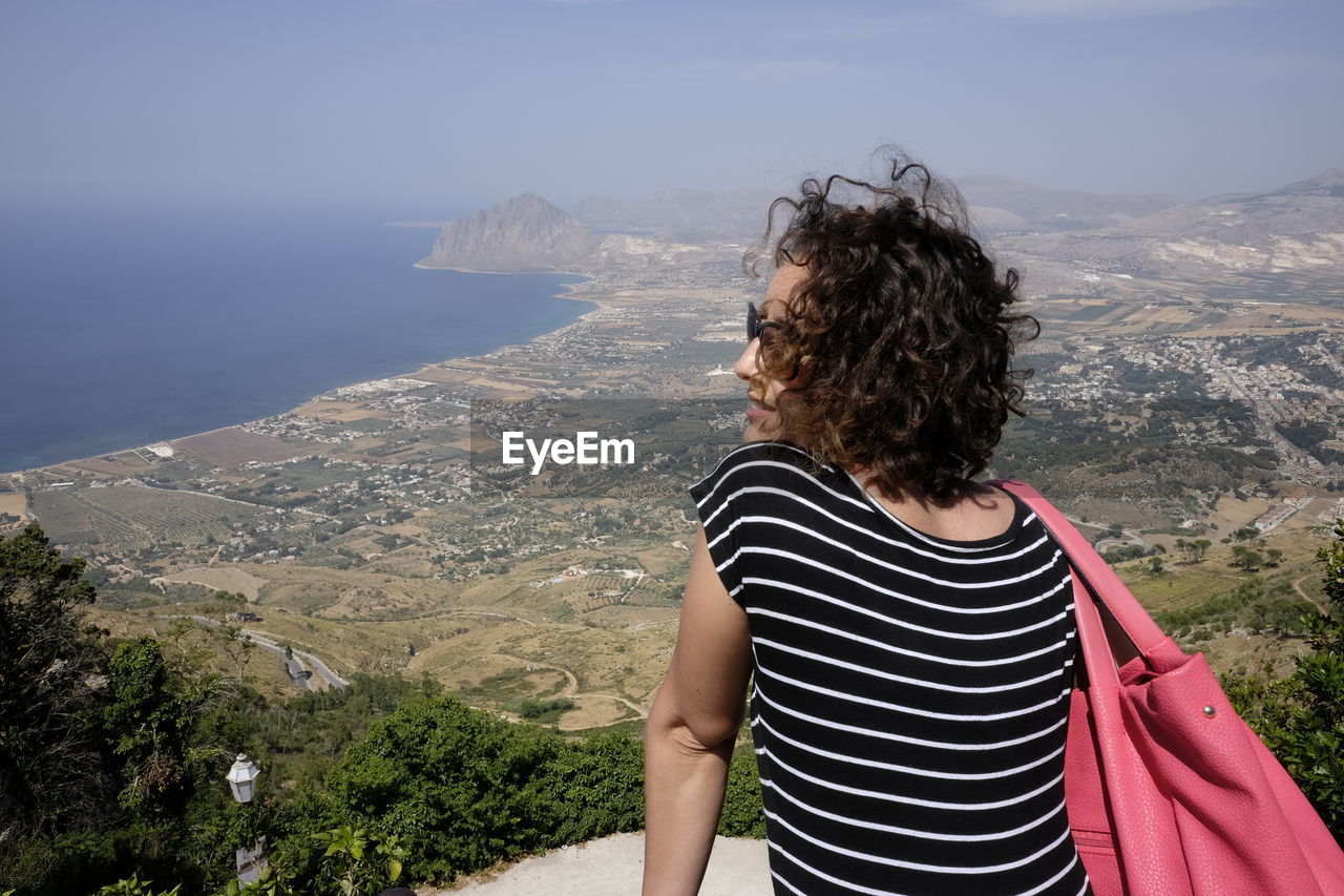 Rear view of woman looking at view from observation point at erice