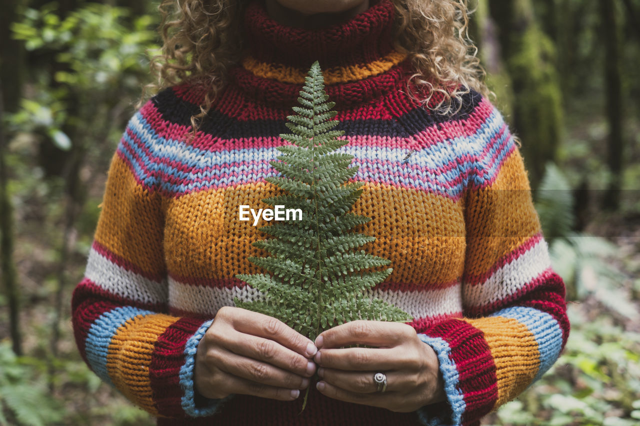 midsection of woman wearing warm clothing standing in forest