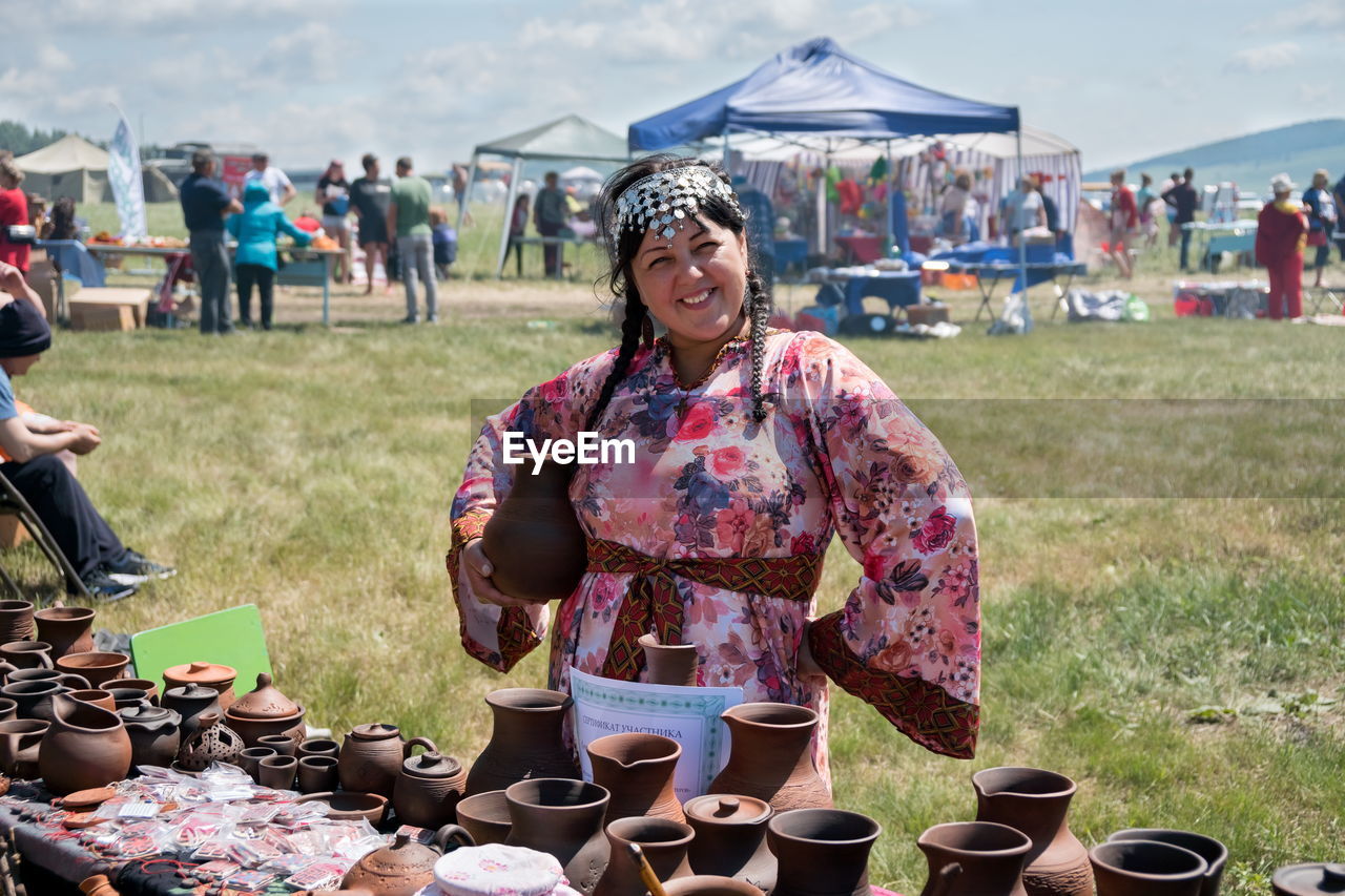 adult, women, nature, day, smiling, arts culture and entertainment, crowd, happiness, clothing, one person, market, food and drink, lifestyles, music, outdoors, grass, focus on foreground, emotion, event, festival, young adult, leisure activity, music festival, portrait, food, looking at camera, men