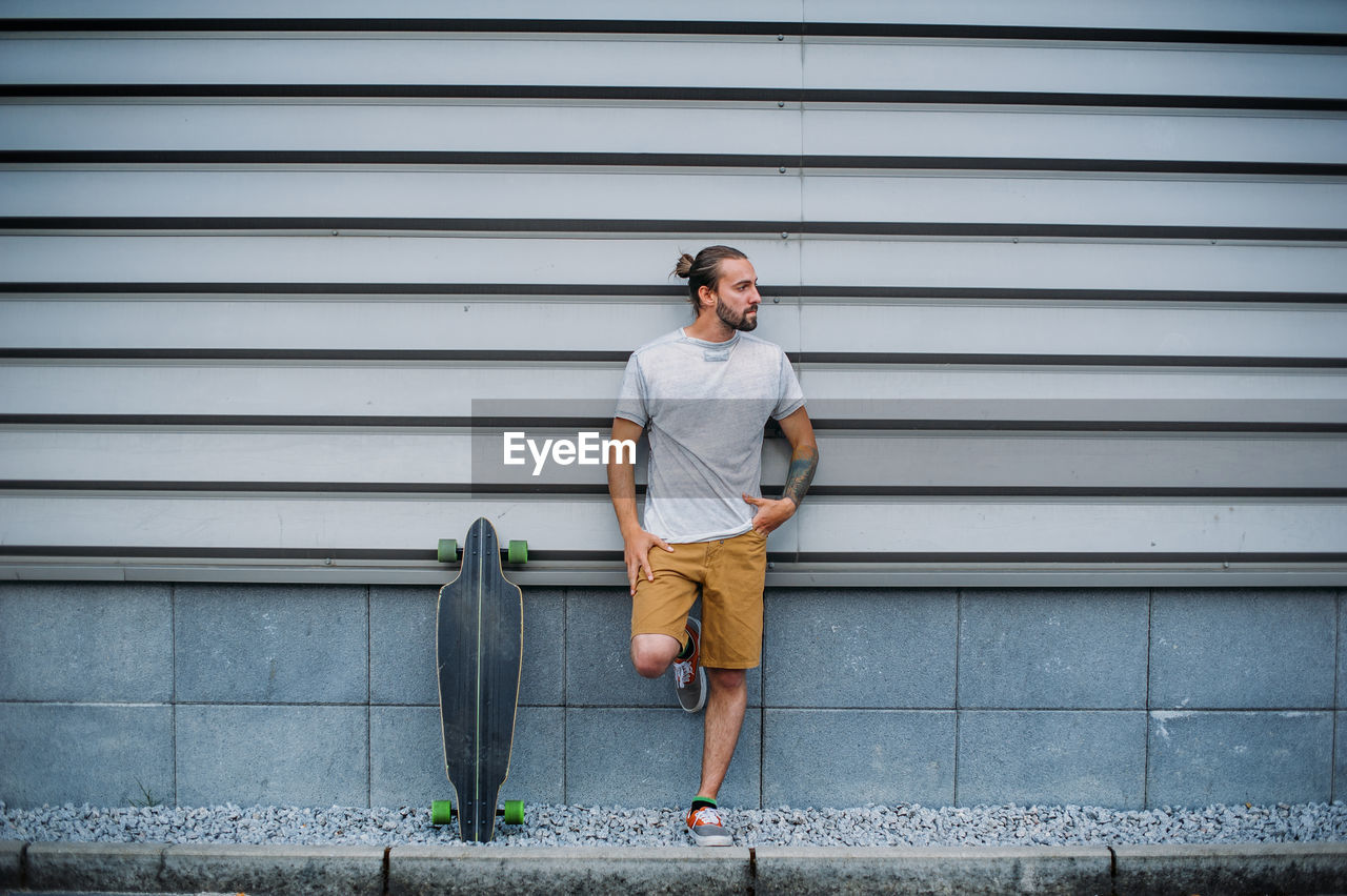 Boy posing with skateboard in hand