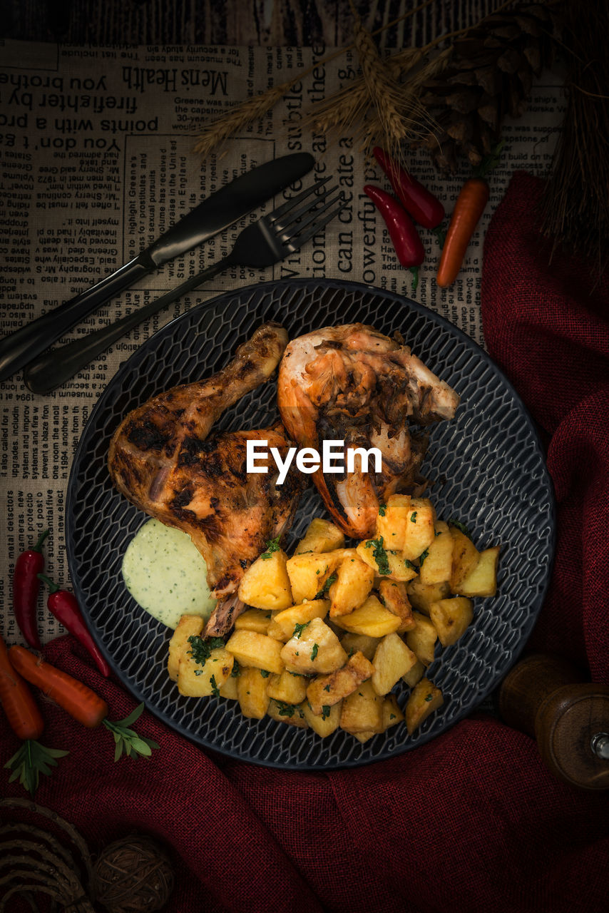 Directly above shot of fried chicken and fried potatoes in plate