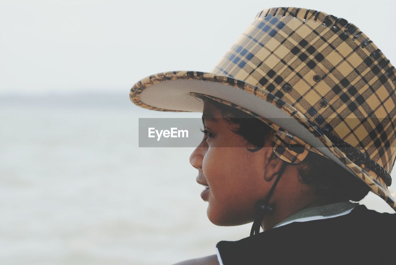 Close-up portrait of boy wearing hat against sky