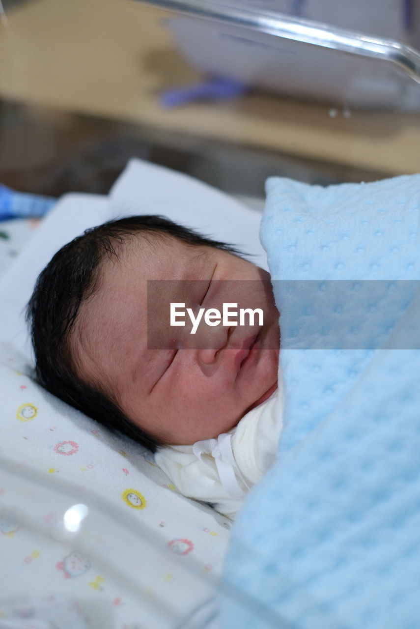 close-up of cute baby boy lying on bed