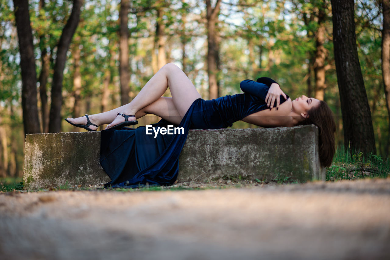 Side view of young woman lying down on land