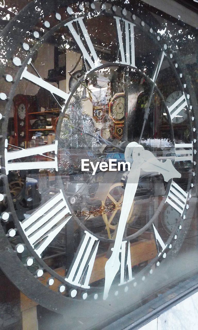 Close-up of clock behind glass window